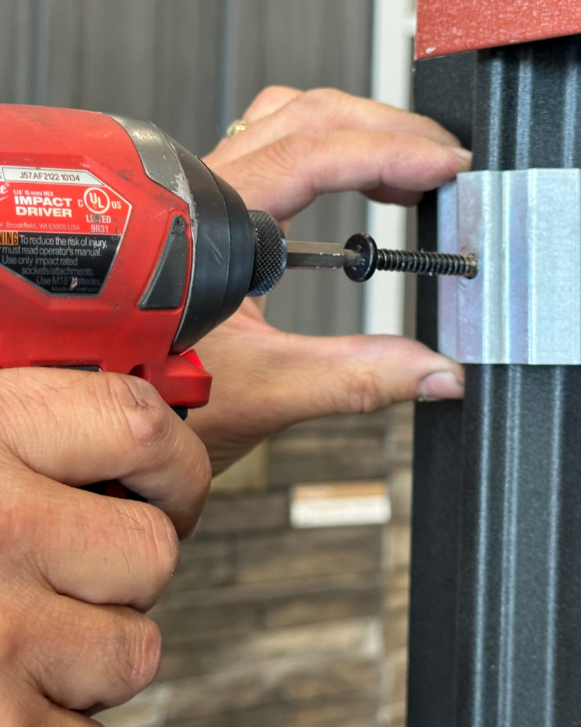 Drill aligning pan head screw into clip and Elite Rib panel of Elite Batten system