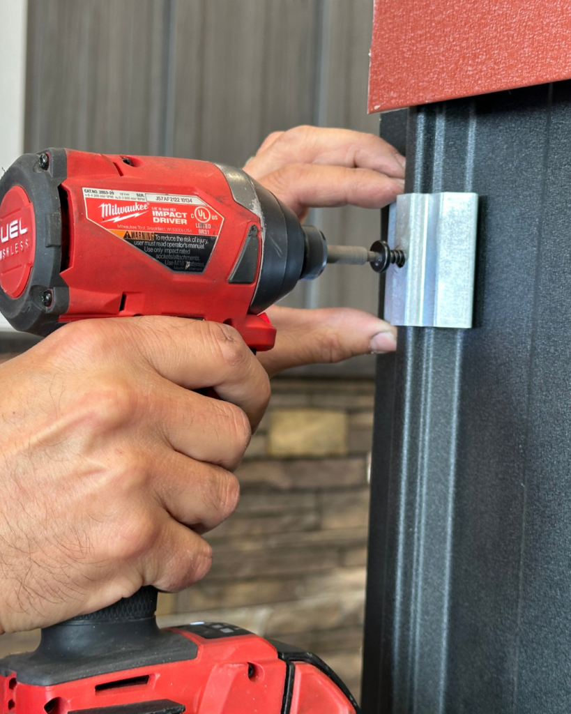 Drill fastening pan head screw through clip into Elite Rib panel during Elite Batten installation