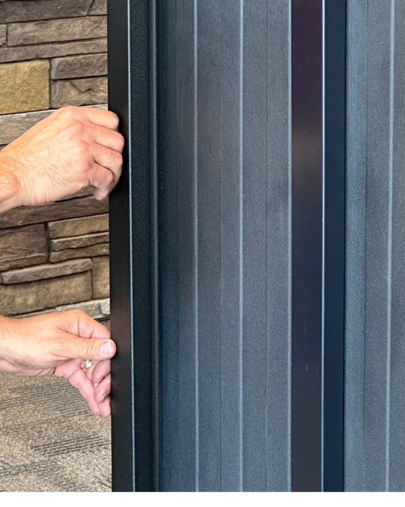 Installer snapping metal batten into Elite Batten's clip system during board and batten installation