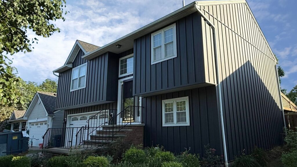 Two-story home exterior finished in dark gray Elite Batten metal siding