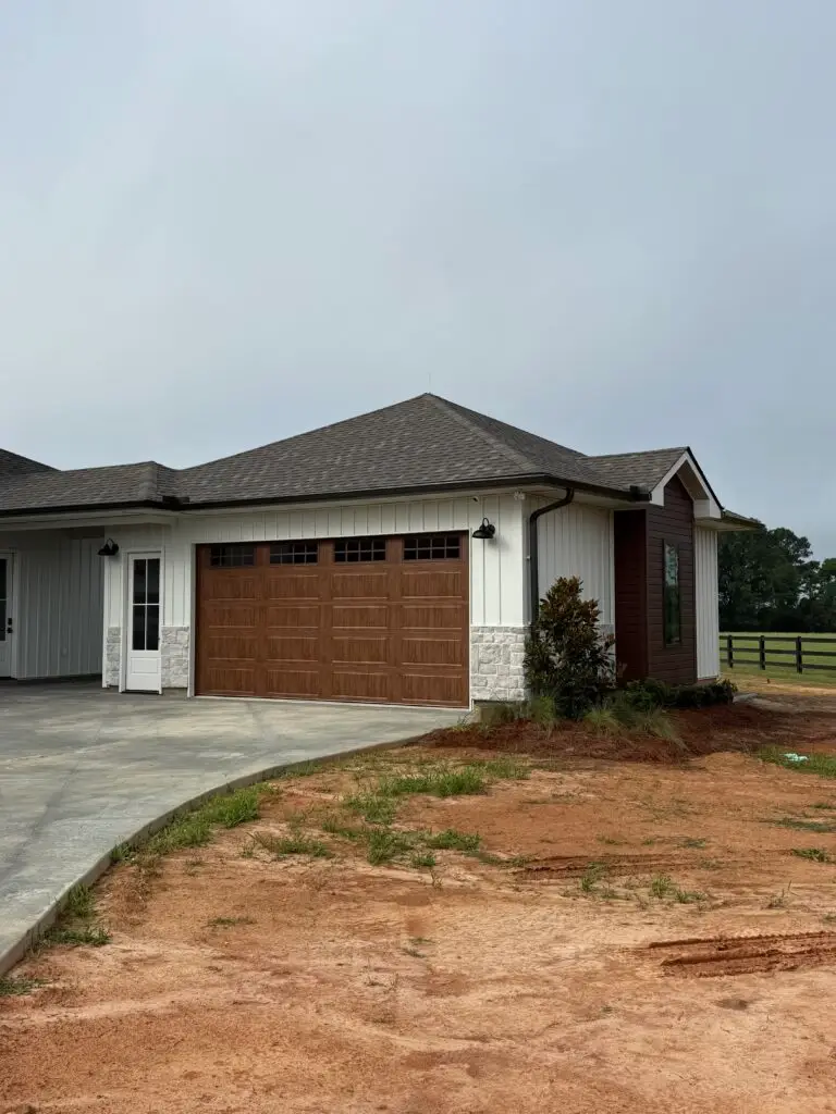 Woodgrain metal siding accent and matching garage door on Bogalusa modern farmhouse